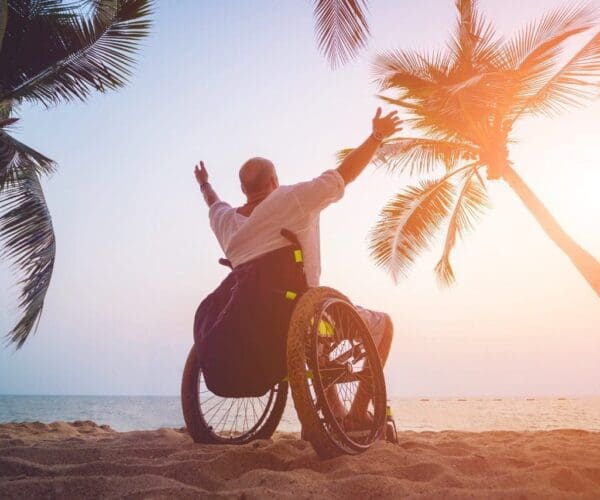 Disabled man in a wheelchair on the beach. Concept background