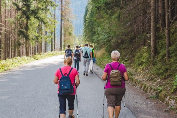 Morske oko, Poland - September 12, 2019: group of people walking by trail seniors with sticks hiking concept