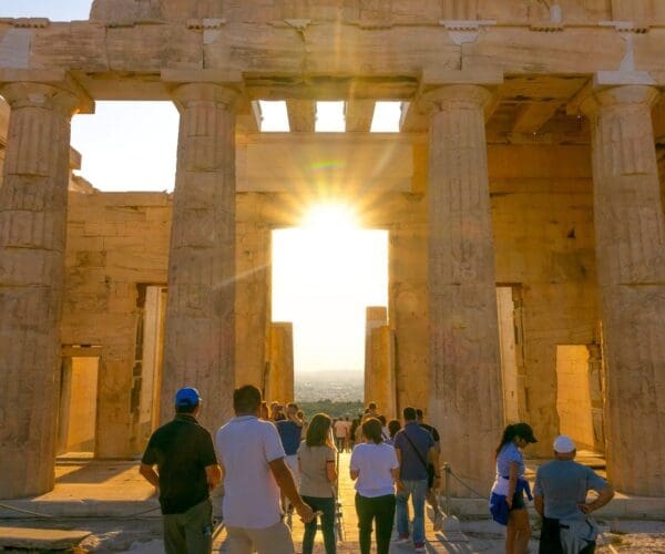 Greece. Sunset over summer Athens. Tourists at the entrance portico to the Parthenon